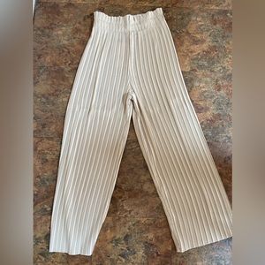 High wasted, pleated trousers in beige/cream color. Size XS